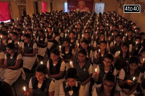 Schoolgirls hold candles as they sit in front of a portrait of former President APJ Abdul Kalam during a prayer ceremony in Chennai on July 28, 2015.