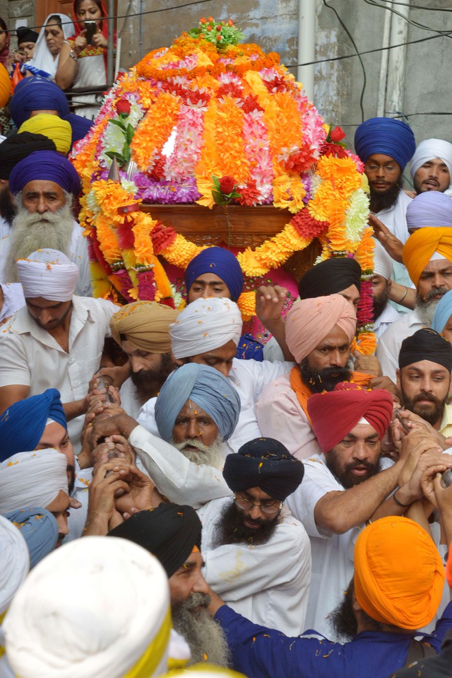 Sikh devotees carry the Palki Sahib with the Guru Granth Sahib as they take part in a procession for Guru Nanak Dev's marriage anniversary, from the Gurdwara Sri Dehra Sahib temple to the Kandh Sahib temple in Batala, some 45 kms (28 miles) northeast of Amritsar on September 20, 2015