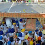 Sikh devotees pay their respects at the Palki Sahib carrying the Guru Granth Sahib during a procession for Guru Nanak Dev's marriage anniversary from the Gurdwara Sri Dehra Sahib temple to the Kandh Sahib temple in Batala, some 45 km (28 miles) northeast of Amritsar on September 20, 2015