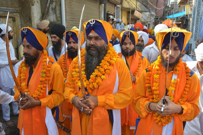 Sikh holy men, known as Punj Pyara, carry swords as they take part in a procession for Guru Nanak Dev's marriage anniversary from the Gurdwara Sri Dehra Sahib temple to the Kandh Sahib temple in Batala, some 45 km (28 miles) northeast of Amritsar on September 20, 2015. The marriage anniversary is celebrated every year at Batala and devotees come from various places to take part in the celebrations