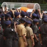 Soldiers use their mobile phones to take pictures of the body of former President APJ Abdul Kalam, wrapped with the national flag, outside Kalam's residence in New Delhi on July 28, 2015.