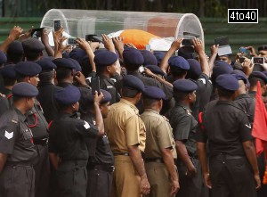 Soldiers use their mobile phones to take pictures of the body of former President APJ Abdul Kalam, wrapped with the national flag, outside Kalam's residence in New Delhi on July 28, 2015.