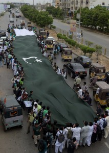 Students carry a national flag as they march on a street ahead of the country's forthcoming Independence Day celebrations in Karachi.