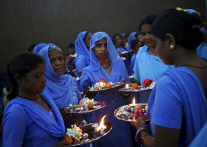 Women holding plates decorated with religious items wait to tie rakhi to Hindu saints during a function organised by non-governmental organisation Sulabh International to celebrate Raksha Bandhan festival in New Delhi on August 28, 2015. Dozens of the women, who used to clear human waste for a living, a practice which is now banned in India, on Friday participated in the celebrations for the first time this year, according to the organisers