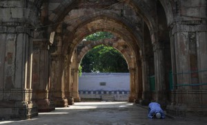 A Muslim devotee offers prayers to mark the festival of Eid al-Adha at the mosque and tomb of Hazrat Qutub-E Alam in the Vatva area of Ahmedabad on September 25, 2015