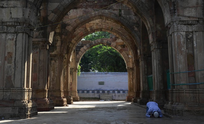 A Muslim devotee offers prayers to mark the festival of Eid al-Adha at the mosque and tomb of Hazrat Qutub-E Alam in the Vatva area of Ahmedabad on September 25, 2015