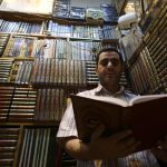 A Syrian man reads a copy of the Quran, Muslim's holy book, at a book stall in a market in the capital Damascus on June 5, as people prepare for the holy month of Ramadan due to start this week.