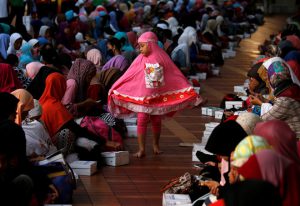 A child walks between Muslim women waiting to break the fast during the holy month of Ramadan inside Istiqlal mosque in Jakarta, Indonesia June 6.