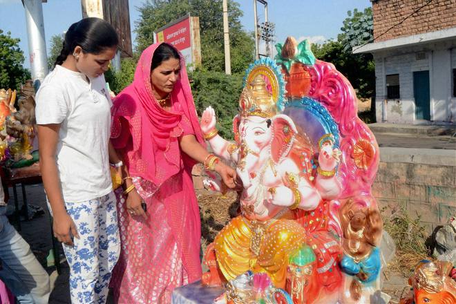 A girl and a woman purchase an idol of Lord Ganesha for the Ganesh festival in Jodhpur, Rajasthan, on September 15, 2015