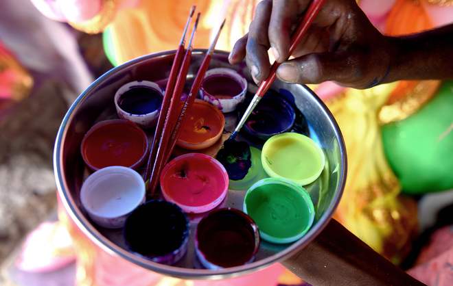 A labourer mixes paint as he prepares to give the finishing touches to a statue of Lord Ganesha ahead of the Ganesh Chaturthi festival at a workshop in Chennai on August 28