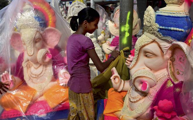 An artist gives finishing touches to an idol of Lord Ganesha ahead of Ganesh Chathurthi festival in New Delhi