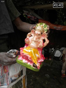 Artist displays freshly painted statue of Lord Ganesha at Deepali Chowk, Rohini, New Delhi