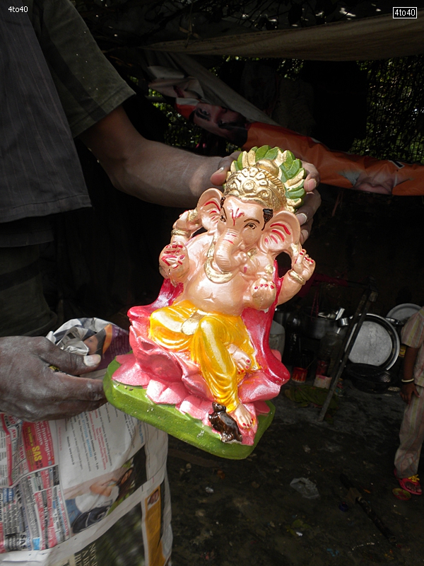 Artist displays freshly painted statue of Lord Ganesha at Deepali Chowk, Rohini, New Delhi