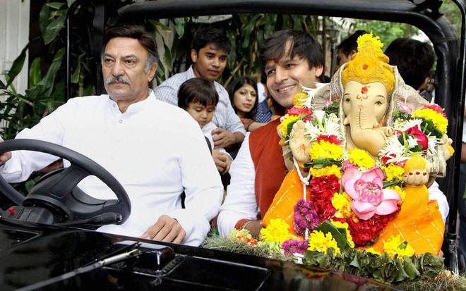 Bollywood actors Suresh Oberoi and Vivek Oberoi carry idols of Hindu elephant god Lord Ganesha for immersion ion the fifth day of the Ganesh festival