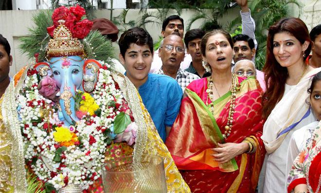 Bollywood actress Dimple Kapadia and daughter Twinkle Khanna pray to an idol of the Hindu elephant god Lord Ganesh before it is immersed into the sea