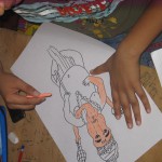 Children coloring a sketch of Lord Ganesha