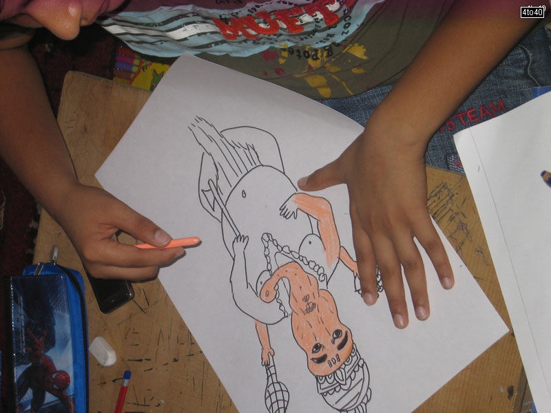Children coloring a sketch of Lord Ganesha