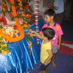 Children giving swing to Balkrishna idol on eve of Janmashtami Festival