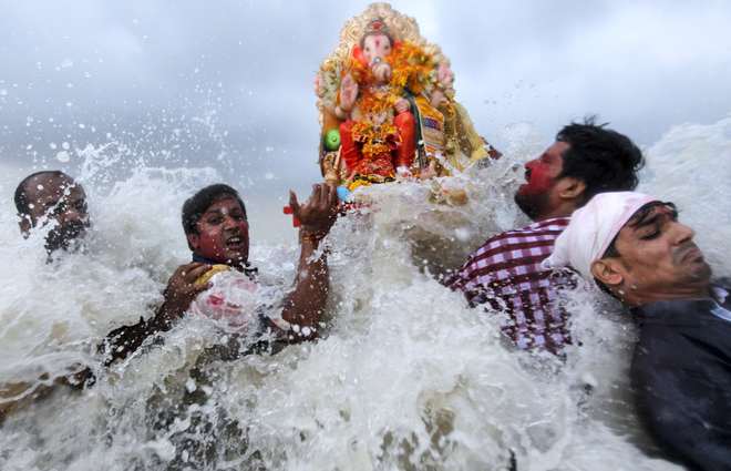 Devotees carry an idol of the Hindu elephant god Lord Ganesh into the Arabian Sea