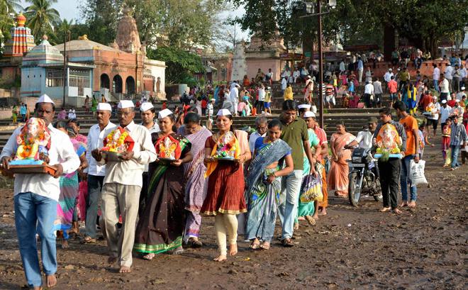 Devotees carry idols of Hindu elephant god Lord Ganesha for immersion into Krishna river