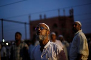 Muslim men look towards the sky to spot the crescent moon, on the eve of the holy fasting month of Ramadan, at the Jama Masjid (Grand Mosque) in the old quarters of Delhi, June 6.