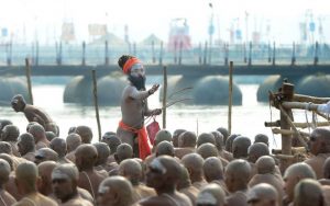 Newly initiated Naga Sadhus (Hindu holy men) sit as they perform rituals on the banks of the Ganges river during the Kumbh Mela, in Allahabad.