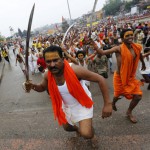 Sadhus or Hindu holy men hold swords as they run towards the banks of Godavari river to take a dip during the second ‘Shahi Snan’ (grand bath) at Kumbh Mela or Pitcher Festival in Nashik, on September 13, 2015