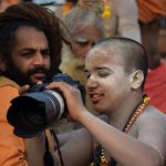 Sadhus shoot on a DSLR camera on a bank of Ganga river during the ongoing Kumbh Mela festival, in Allahabad.
