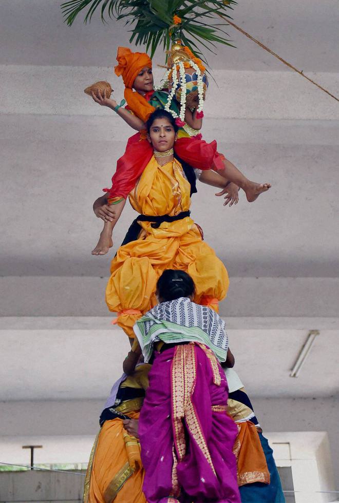 Students from a girls’ college form a pyramid to break a pot of curds tied high up with a string in a ritual called Dahi Handi as part of Janmasthami celebrations in Mumbai on September 5, 2015. Janmasthami marks the birth anniversary of Hindu Lord Krishna. ‘Dahi Handi’ is a ritual observed primarily in Maharashtra