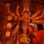 A Hindu priest offers evening prayer in front of an idol of the Goddess Durga in New Delhi on late October 20,2015