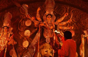 A Hindu priest offers evening prayer in front of an idol of the Goddess Durga in New Delhi on late October 20,2015