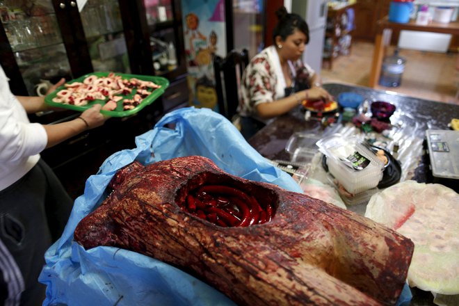 A bloody, fake open torso with jelly guts made of gummy candy is seen as a woman works at the Zombie Gourmet homemade candy manufacturer on the outskirts of Mexico City on October 30, 2015.