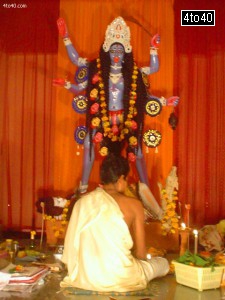 A priest performing puja at Mahakali Statue