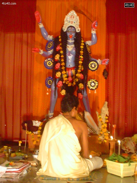 A priest performing puja at Mahakali Statue