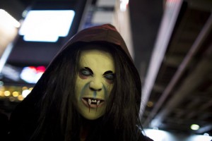 A reveller wearing a mask poses for pictures during Halloween celebrations in the Shibuya district in Tokyo n October 31, 2015