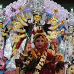 A young Hindu unmarried girl, known as a 'kumari', and dressed as the Hindu goddess Durga, puts her hand up during a ritual for the Durga Puja festival at Ramakrishna Mission in Agartala on October 21, 2015