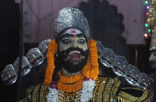 An Indian artiste dressed as demon king Ravana laughs during a religious procession ‘Ravan ki Barat’ in Allahabad on September 26, 2016, held to mark the Dussehra festival.