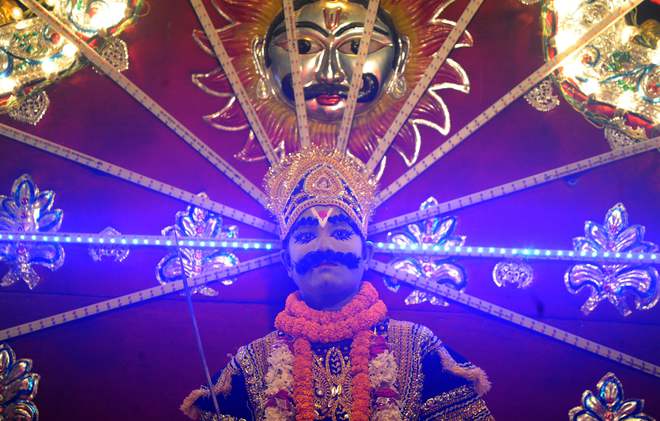 An Indian artiste dressed as son of Hindu demon king Ravana, Meghnath, sits on a chariot, as he takes part in a ‘Ravan ki Barat’ religious procession held to mark the forthcoming Dussehra festival in Allahabad on September 26, 2016.