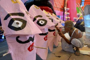 An artist paints the face of Hindu demon King Ravana in Surat on October 20, 2015, ahead of the Hindu festival of Dussehra