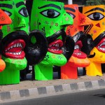 An motorcyclist passes by the effigies of the demon king of Hindu Mythology, Ravana, displayed for sale at a roadside in New Delhi on October 20, 2015