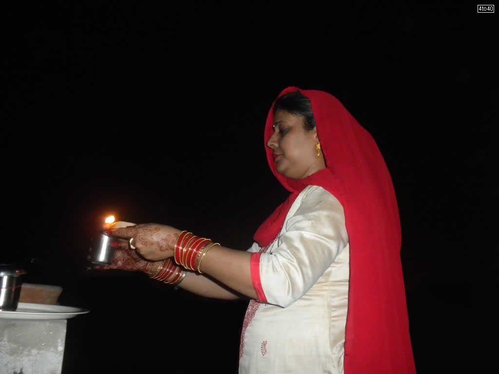 Hindu woman praying for long life of their husband and breaks the fast by looking at the moon on Karva Chauth night