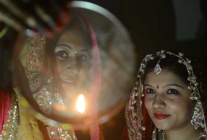 Indian Hindu married women perform a ritual on Karwa Chauth, a traditional Hindu festival celebrated in northern India during which married women fast one whole day and offer prayers to the moon for the welfare, prosperity, and longevity of their husbands, in Siliguri on October 30, 2015