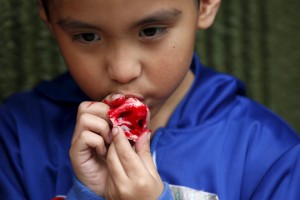 Logan Rios, 5, eats a bloody ear made of gummy candy and red jelly at the Zombie Gourmet homemade candy manufacturer on the outskirts of Mexico City on October 30, 2015. A candy maker in Mexico is raising the stakes this Halloween when it comes to spooky with chewable candy ears and an edible candy foetus for the ultimate prankster. Joyce Martias set up her business