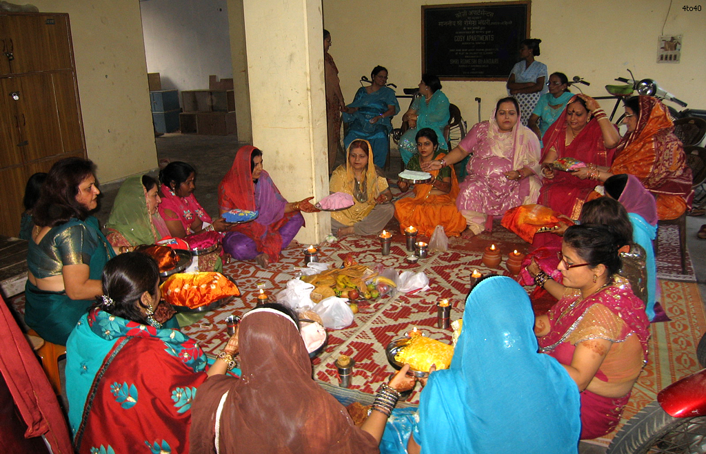 Married women exchange thalis while offering prayers for their husbands welfare prosperity and longevity on Karwa Chauth at Cosy Apartments, Sector 9, Rohini, New Delhi