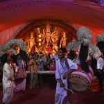 Musicians play drums as a Hindu priest offers evening prayer in front of an idol of the Goddess Durga in New Delhi on late October 20,2015