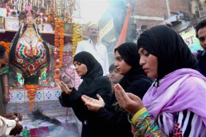 Muslim women offer prayers in front of a Tazia during a Muharram procession in Bhopal