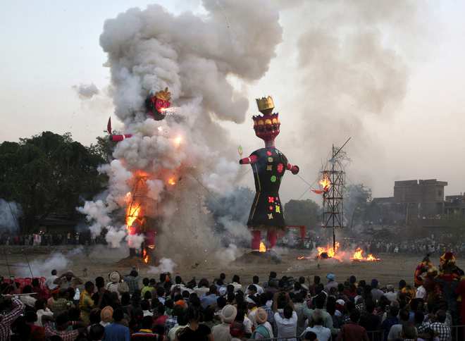 People watch as effigies of demon king Ravana (C), his brother Kumbhkarana and son Meghnad (R) are burnt during the Hindu festival of Dussehra in Amritsar