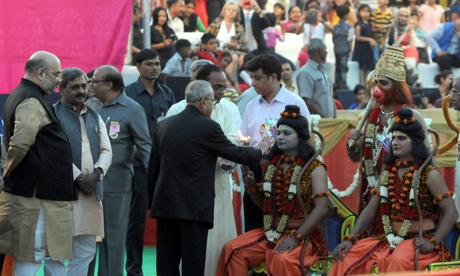 President Pranab Mukherjee offers his prayers to a man dressed as Hindu God Ram and Lakshman during Dussehra celebrations at the Red Fort Grounds in New Delhi on Thursday. BJP president Amit Shah also pictured