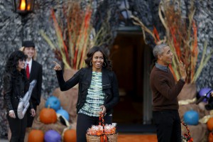 US President Barack Obama and first lady Michelle Obama wave as they arrive at a Halloween trick-or-treating celebration on the South Lawn of the White House in Washington on October 30, 2015