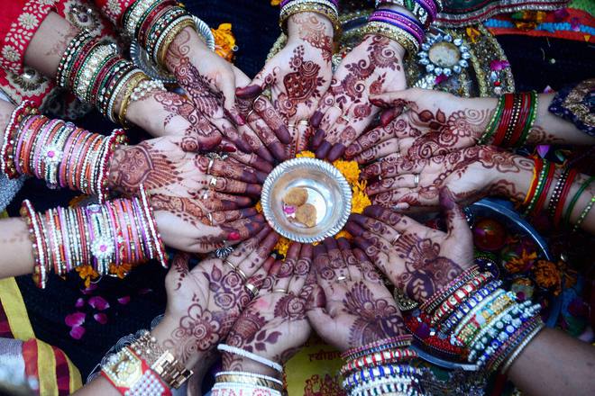 Women a perform ritual on Karva Chauth, traditional Hindu festival celebrated in northern India during which married women fast one whole day and offer prayers to the moon for the welfare, prosperity, and longevity of their husbands, in Ahmedabad on October 22, 2015
